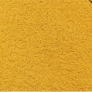 May include: A close-up of a yellow bath mat with a soft, fluffy texture.