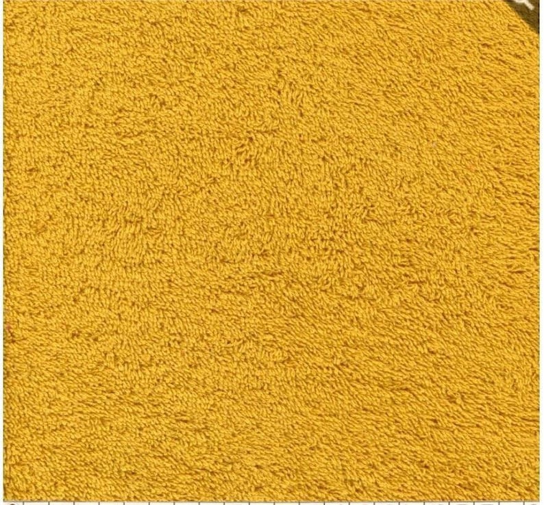 May include: A close-up of a yellow bath mat with a soft, fluffy texture.