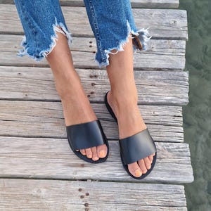 黒革の女性用スライド、ギリシャの革サンダル、グラディエーターサンダル、ミュール、スリッポンサンダル、夏用フラットシューズ、レザーシューズ、女性用プールスライド