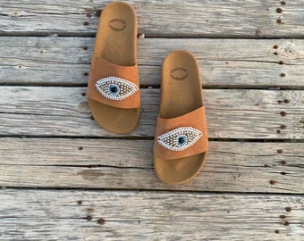 ベージュのレザーで装飾されたスライド、ハンドメイドサンダル、女性用ミュールシューズ、イーブルアイ、スリッポンサンダル、ギリシャの夏の剣闘士、夏のフラットシューズ