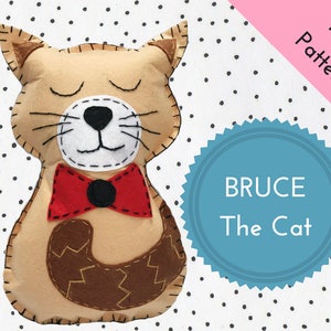 Könnte beinhalten: Ein PDF-Muster zum Nähen eines Plüschkatzenspielzeugs namens "Bruce the Cat". Die Katze ist beige mit einer roten Schleife und einem braunen Schwanz. Das Muster steht zum Download bereit.