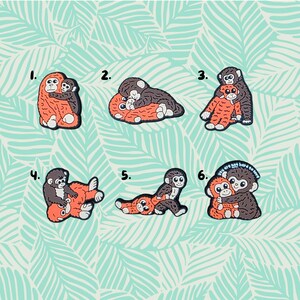 May include: A selection of six monkey stickers. Each sticker shows a mother monkey and baby monkey in various poses, in shades of orange, brown, and grey. The background is a light teal colour with a repeating leaf pattern. One sticker has the text "you are not hard to love".