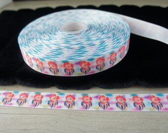 Może przedstawiać: Rolka białej wstążki z kolorowym wzorem tie-dye i wzorem łapacza snów. Wstążka jest zwinięta, a koniec leży płasko na czarnej powierzchni.