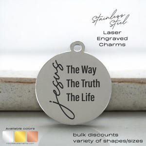 May include: Silver charm with the words "Jesus", "The Way", "The Truth", and "The Life" engraved on it. The charm is round and has a hole at the top for attaching to a necklace or bracelet.