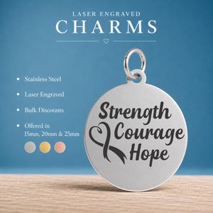 May include: A round silver-colored stainless steel charm with a jump ring. The charm features a laser-engraved awareness ribbon symbol and the text Strength Courage Hope. The image includes text stating Laser Engraved Charms and size options.