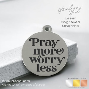 May include: A stainless steel, laser-engraved charm with the words "Pray more worry less" in a bold, serif font. The charm is round with a small loop at the top. Additional text includes "bulk discounts" and "variety of shapes/sizes."