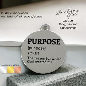 May include: A silver round charm with the word "PURPOSE" in black lettering. The charm also includes the definition of the word "purpose" and the phrase "The reason for which God created me."