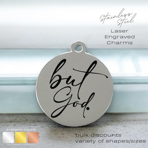 May include: A silver round charm with the words "but God" engraved in black script. The charm is available in silver, gold, and rose gold.