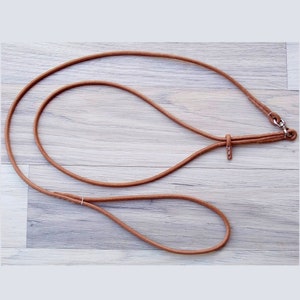 Natural coloured, round leather dog leash. The leash is made up of a neckpiece and a leash part, they are connected by a chrome plated swivel. The neckpiece/collar is fitted with a leather stopper to fix the size of the collar.