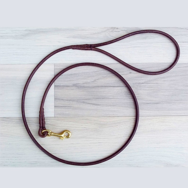 Clip on dog leash. Round brown leather with a brass clip.