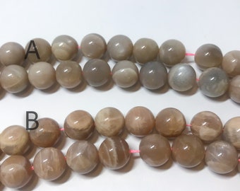 May include: Two strands of light brown sunstone beads. The beads are round and have a smooth, polished finish. The beads are strung on a pink thread.