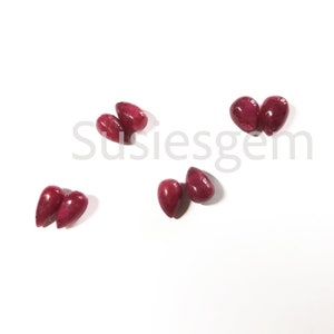 以下が含まれることがあります： 涙の形をした赤い宝石のビーズが6つ。ビーズは滑らかで磨かれており、サイズと形にわずかな違いがあります。