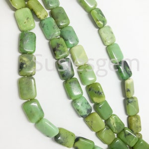 May include: A strand of green gemstone beads, each bead is rectangular and has a smooth, polished finish. The beads are strung together on a clear thread.