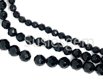 May include: A strand of black faceted gemstone beads. The beads are round and have a polished finish.