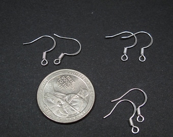 May include: Six silver earring hooks, each with a spring closure, are displayed on a black surface. A US quarter is included for size reference.