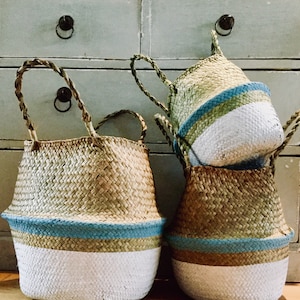 Può includere: Tre cesti intrecciati con strisce dipinte di blu e bianco. I cesti sono realizzati con materiali naturali e hanno un aspetto rustico.