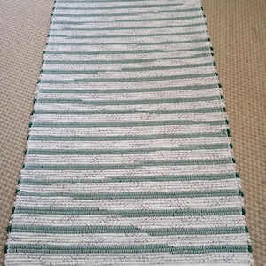 Woven rag rug.  Green, tan and little burgundy. Measures 25 by 50 inches.  Shipping incl.  JW81