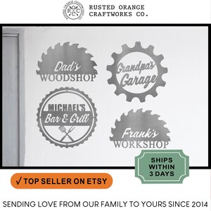 May include: Four metal signs with different designs and text. The signs are mounted on a white wall. The signs read "Dad's Workshop", "Grandpa's Garage", "Michael's Bar & Grill", and "Frank's Workshop".