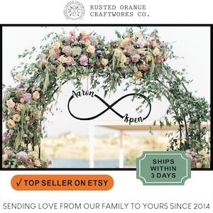 May include: Black metal infinity symbol with the names "Aaron" and "Aspen" written on it. The symbol is hanging from a floral archway. The text "Top Seller on Etsy" is visible at the bottom of the image.