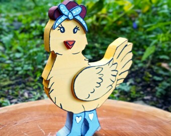 May include: A yellow wooden chicken figurine featuring a dark red comb, a light blue bandana with white heart patterns, and matching light blue boots with white heart details. The chicken has black painted eyes and an orange beak.