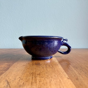 May include: A set of three ceramic mugs with a speckled, matte finish. The mugs are in shades of cream, light gray, and dark gray. Each mug has a simple, minimalist design, perfect for coffee or tea.