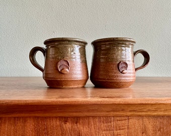 Pair of vintage studio pottery mugs / green and brown handmade coffee cups with shell motif signed by artist