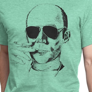 Puede incluir: Una ilustraci&oacute;n en blanco y negro de un hombre con la cabeza rapada que lleva gafas de sol y fuma un cigarrillo.