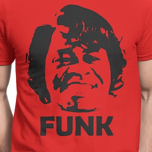 Może przedstawiać: Czerwony T-shirt z czarną sylwetką twarzy mężczyzny i napisem "FUNK" nadrukowanym czarnym kolorem pod twarzą.