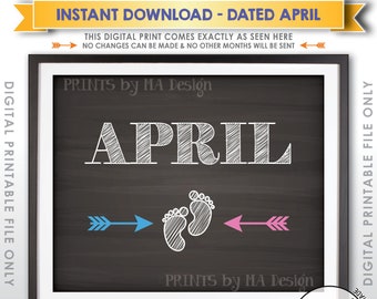 May include: A digital print featuring a dark chalkboard background with the white text APRIL centered at the top. Below the text are two white baby footprints flanked by a blue arrow pointing left and a pink arrow pointing right. The design is framed.