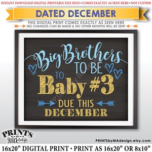 Può includere: Stampa digitale incorniciata con sfondo stile lavagna. Il testo recita "Big Brothers to Be Baby #3 Due This December" in scrittura blu e gialla. La stampa è disponibile in dimensioni di 40,64 x 50,8 cm o 20,32 x 25,4 cm.