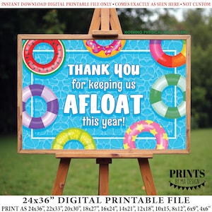 Może przedstawiać: Cyfrowy plik do druku na sztaludze. Znak ma niebieskie tło z kolorowymi kołami ratunkowymi i tekstem "THANK YOU for keeping us AFLOAT this year!". Znak jest dostępny w różnych rozmiarach, w tym 61x91cm.