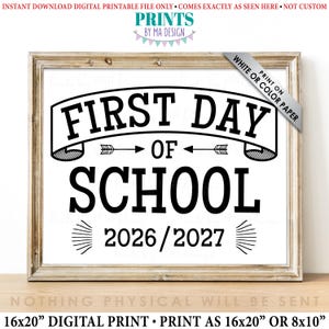 May include: A rectangular digital print in a wooden frame featuring the black text FIRST DAY OF SCHOOL 2026/2027. The design includes a banner graphic, two arrows pointing toward the word OF, and decorative lines flanking the year.