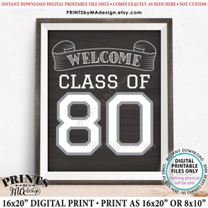 Puede incluir: Un cartel imprimible en blanco y negro con el texto "Welcome Class of 80" en una fuente de estilo vintage. El cartel está enmarcado en un marco de madera marrón.