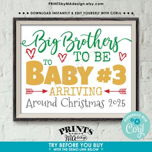 May include: Framed print with the text "Big Brothers to be Baby #3 Arriving Around Christmas 2025." The design features green and gold lettering with red heart accents and arrows. The print is from PrintsbyMAdesign.etsy.com.