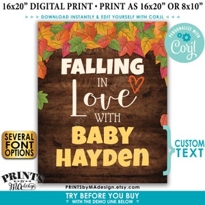 K&ouml;nnte beinhalten: Ein digitaler druckbarer Schild mit rustikalem Holz Hintergrund und Herbstbl&auml;ttern. Der Text lautet "Verliebt in Baby Hayden".