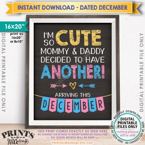 May include: A framed chalkboard-style print with the text "I'm so cute Mommy & Daddy decided to have ANOTHER!" in yellow, blue, and pink. The print announces a December arrival and is available as a digital download, sized 16x20 inches or 8x10 inches.