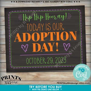 May include: A chalkboard sign with the text "Hip Hip Hooray! Today is our Adoption Day!" in green, orange, and purple text. The date "October 29, 2023" is written in purple text below the main text.