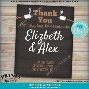 May include: A black chalkboard sign with white text that says "Thank You for helping to celebrate Elizabeth & Alex". The sign has a brown border and a graphic of two marshmallows on sticks with flames coming off of them. The text "Please take s'more fun home with you!" is also on the sign. The sign is for a wedding or engagement party.