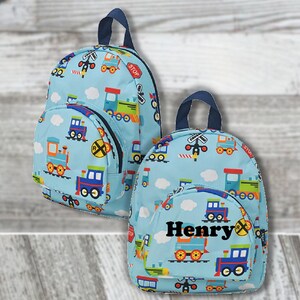 May include: Two light blue backpacks with a train pattern. The backpacks feature a repeating pattern of colorful trains, railroad crossings, and clouds. One backpack has the name "Henry" printed on the front.