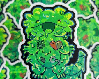 May include: Green and yellow slime monster sticker with a heart and a leaf on its chest. The monster has a big smile and is dripping slime.