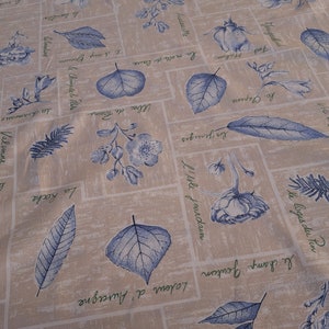 May include: A beige fabric with a blue and green floral pattern. The fabric features a variety of leaves, flowers, and text in French. The text includes words like "la roche", "le logis du tin", and "les moulins roux".