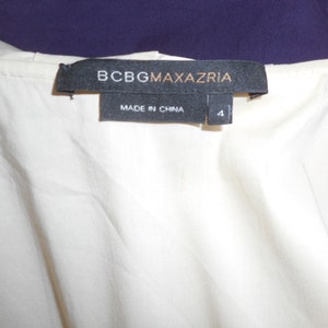 May include: A white tag with black text that reads "BCBGMAXAZRIA" and "MADE IN CHINA". The tag also has a size label that reads "4".