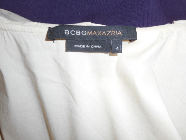 May include: A white tag with black text that reads "BCBGMAXAZRIA" and "MADE IN CHINA". The tag also has a size label that reads "4".