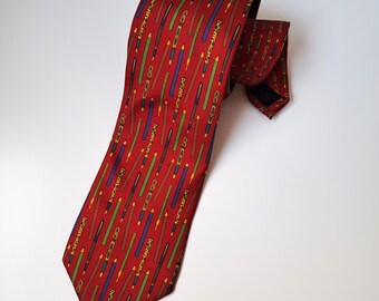 May include: A red silk tie with a pattern of colorful pens and pencils.