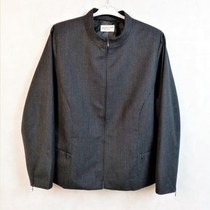 Puede incluir: Una chaqueta blazer gris oscuro con cierre de cremallera y cuello alto. La chaqueta tiene una etiqueta que dice "Pendleton" en el interior del cuello.