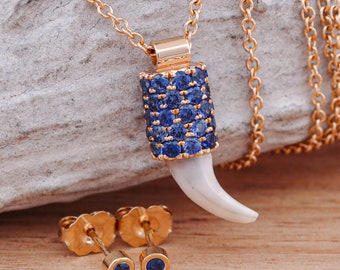 Pendentif dent de chien en or 14 carats avec pavé de saphirs bleus