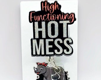 May include: A silver glitter badge holder with the text "High Functioning Hot Mess" in black and pink. The badge holder has a clear plastic retractable badge holder with a rhino cartoon charm.