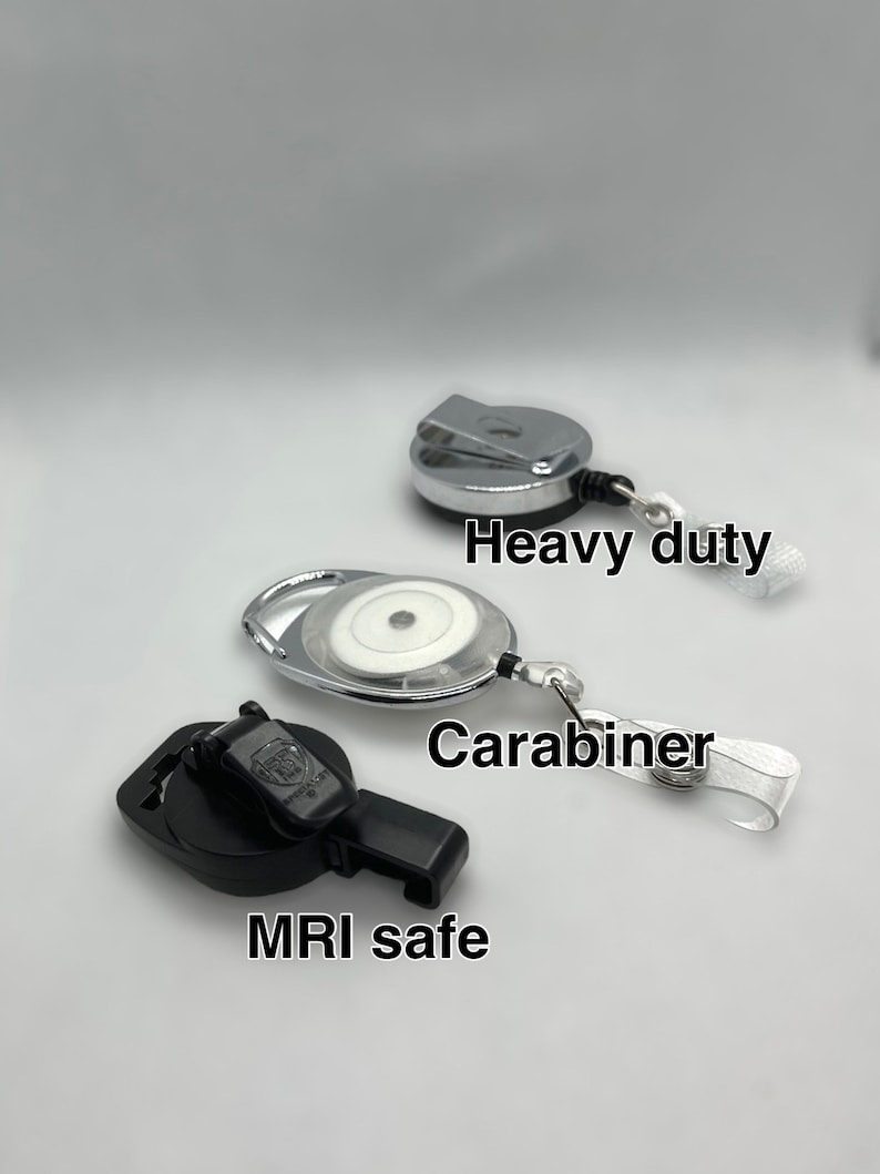 May include: Three different types of retractable badge reels. The top reel is silver and has the text "Heavy duty". The middle reel is silver and has the text "Carabiner". The bottom reel is black and has the text "MRI safe".