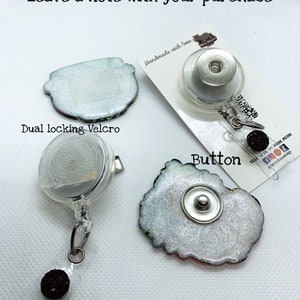 May include: Three different ways to attach a badge reel. The first option is a dual locking Velcro, the second is a button, and the third is a clear plastic clip. The text "Handmade with love" is visible in the image. The text "Orders come glued unless requested otherwise." is also visible in the image.