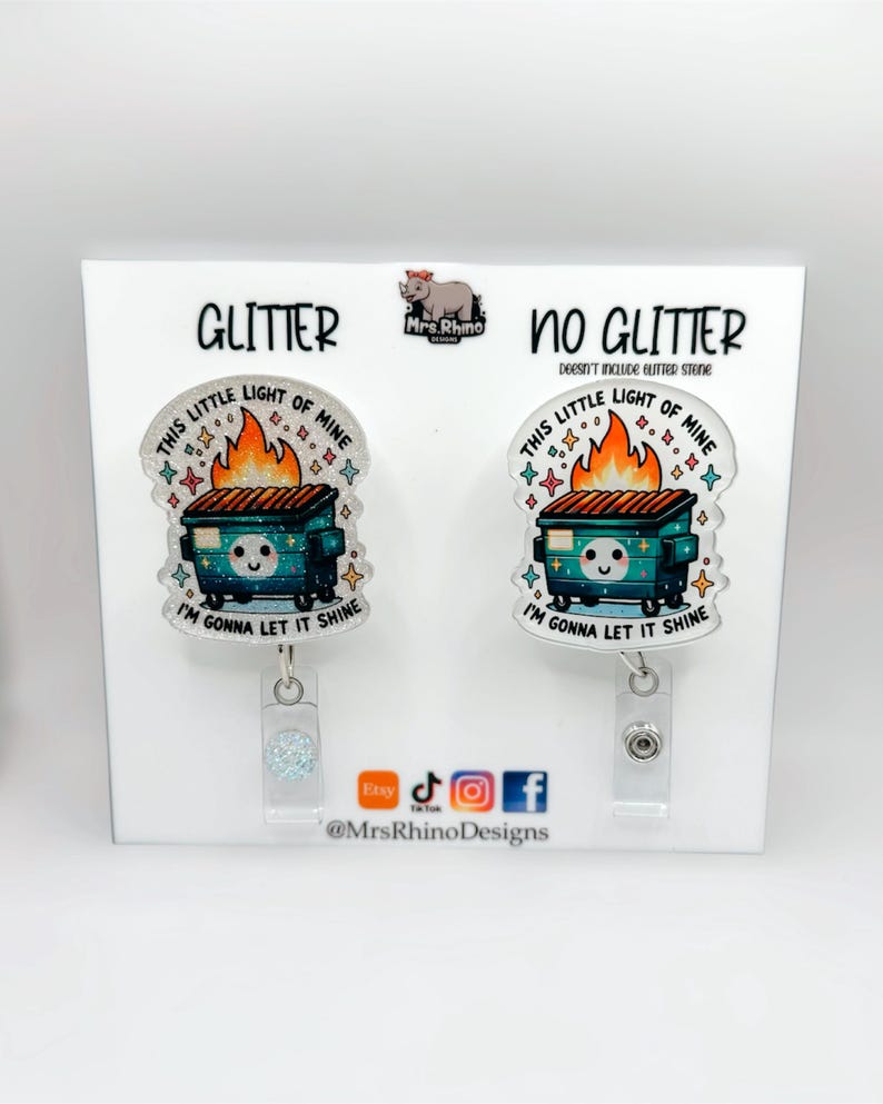 Pu&ograve; includere: Due porta badge con un design a cassonetto. Uno &egrave; etichettato "Glitter" e l'altro "No Glitter". Ogni porta badge ha il testo "This little light of mine, I'm gonna let it shine". I porta badge sono su un espositore bianco.